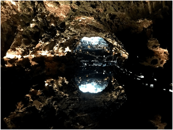 La entrada a la cueva de los Jameos del Agua, repleta de palmeras y con una piscina, resulta espectacular tanto de día como de noche.
